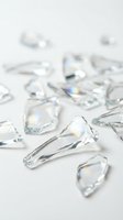 Clear crystal teardrop beads scattered on white surface, isolated design elements with prismatic light refraction, suitable for jewelry making, crafts, and decorative projects.