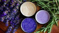 Colorful healthy smoothies in glasses with fresh lavender flowers on wooden background. Purple butterfly pea, berry and vanilla protein drinks for wellness.