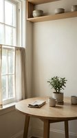 Minimalist kitchen corner with wooden table, ceramic bowls, potted plant and natural light creating warm cozy atmosphere for home decor and interior design.