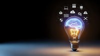 Glowing light bulb with brain and technology icons representing innovation, creativity, artificial intelligence and digital transformation concepts.
