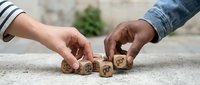 Two hands arranging wooden dice with star rating symbols on concrete surface for customer feedback and business evaluation concepts.