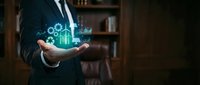 Businessman in dark suit holding glowing digital hologram with upward trending graph, gears, and financial icons, representing growth, technology, and business success.