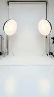Professional photography studio setup with white backdrop and lighting equipment for commercial photo shoots and video production.