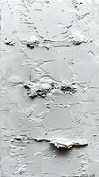 White textured plaster wall with rough uneven surface showing layers of paint and concrete, creating abstract relief pattern with natural shadows and depth.