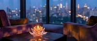 Cozy evening living room with glowing lotus candle holder on coffee table, city lights view through windows, warm ambient lighting for relaxation.