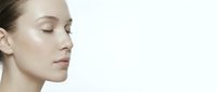 Young Caucasian woman with closed eyes in profile showing natural skincare and beauty routine on clean white background for cosmetic advertising.