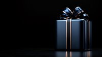 Elegant navy blue gift box with metallic silver ribbon bow on dark background with dramatic lighting and reflection for luxury presentation.