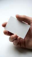 Hand holding blank white business card mockup on neutral background for branding and corporate identity design projects.