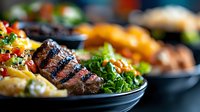 Grilled beef steak with colorful vegetables and herbs on black plate, close up view with selective focus. Restaurant quality meat dish with garnish.