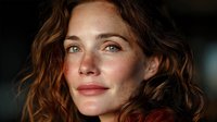 Young Caucasian woman with wavy brown hair and freckles looking thoughtfully at camera with soft natural lighting for portrait photography and lifestyle content.