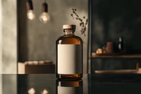 Amber glass bottle with blank label on dark reflective surface, moody atmospheric lighting with hanging bulbs and soft shadows in background interior setting.
