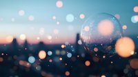 Crystal ball reflects cityscape silhouette at dusk with dreamy bokeh lights creating magical atmosphere for mystical and spiritual concepts.