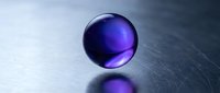 Purple glass sphere with glossy reflection on metallic surface, suitable for abstract backgrounds, technology concepts, and modern design projects.