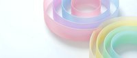 Colorful translucent geometric rings in pastel rainbow hues creating modern abstract composition on white background for contemporary design projects.