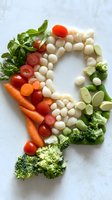 Fresh vegetables and mozzarella balls arranged in curved pattern with carrots, cherry tomatoes, broccoli florets, and herbs on light background for healthy eating concept.