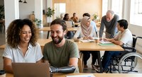 Diverse team of professionals collaborating in modern office workspace with wheelchair accessibility and inclusive environment for business meetings.