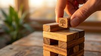 Hand placing wooden block with tree symbol on stacked tower representing sustainable business growth, environmental responsibility and eco-friendly development.