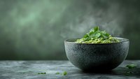 Fresh green cilantro leaves in rustic stone bowl on dark background with atmospheric smoke and copy space, moody food photography styling.