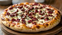 Fresh baked pizza with crispy crust topped with melted mozzarella cheese, spicy chorizo sausage, and herbs on wooden serving board, close up view of gourmet meal.