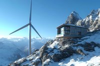 Modern wind turbine and observation station on snowy mountain peak against dramatic alpine landscape with snow-covered peaks and clear blue sky.