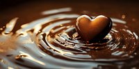 Heart-shaped chocolate candy creating ripples in melted chocolate pool with golden brown tones and smooth liquid texture, macro photography on dark background.