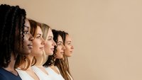 Diverse group of women in profile view showing unity and empowerment in modern workplace or social setting with neutral background.