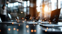 Laptop on office desk with magical sparkles and bokeh lights in dark workspace, sunlight through window creates atmospheric business environment.