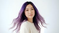 Young Asian woman with vibrant purple ombre hair wearing cream sweater against white background for beauty and fashion concepts.
