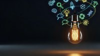 Glowing light bulb with colorful innovation icons floating above on dark background representing creativity, brainstorming and bright ideas for business.