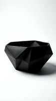 Black matte geometric faceted bowl with angular polygonal design on white background, modern minimalist decorative object for interior styling.