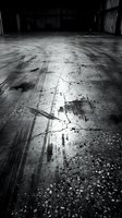 Empty abandoned warehouse interior with cracked concrete floor and dramatic shadows in black and white monochrome style for industrial design projects.