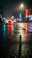 Wet urban street at night with bokeh city lights reflecting on pavement, neon signs glowing in background, shallow depth of field creating atmospheric mood for nightlife and metropolitan concepts.