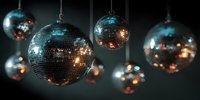 Shiny disco balls hanging in dark nightclub with colorful light reflections creating festive party atmosphere for dance events.