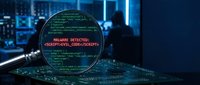 Cybersecurity threat detection with magnifying glass revealing malware code on computer screen in dark tech environment for security analysis.