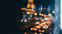 Floating soap bubbles with warm bokeh lights creating magical atmosphere for party decoration and celebration background.