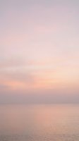 Serene ocean horizon at dawn with soft pink and lavender sky, calm water reflecting gentle light, peaceful seascape for wellness and meditation projects.