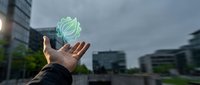 Hand holding glowing green recycling symbol in urban environment representing sustainability and environmental responsibility in modern city.