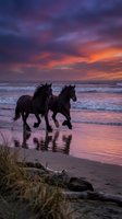 Two wild horses galloping along ocean shore at dramatic sunset with purple and orange sky reflecting on wet sand and waves.