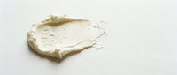 Creamy white cosmetic face mask or moisturizer smear isolated on white background for skincare and beauty product advertising.