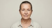Mature Caucasian woman with natural aging lines wearing beige shirt against neutral background. Professional portrait for healthcare and lifestyle concepts.