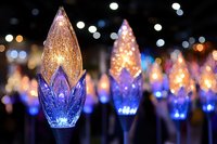 Colorful LED Christmas lights with crystal-like bulbs glowing in blue and amber colors against blurred festive bokeh background for holiday decorations.