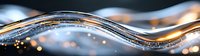 Flowing liquid metal wave with golden sparkles and bokeh effects on dark background creates luxurious abstract panoramic composition.