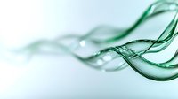 Flowing green liquid waves create elegant abstract curves and ripples against white background, showcasing fluid dynamics and motion in transparent emerald tones.