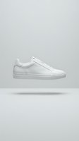 White leather low-top sneaker with minimalist design, isolated on neutral background. Suitable for footwear advertising, e-commerce, fashion catalogs, and retail marketing materials.