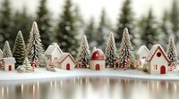 Miniature winter village scene with tiny white houses, snow-covered pine trees, and candy canes reflected in calm water surface creating festive holiday atmosphere.