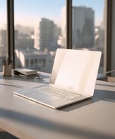 Modern white laptop on desk with city skyline view through large windows, soft morning light creating professional workspace atmosphere.