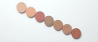 Cosmetic makeup powder compacts in nude and brown shades arranged in diagonal line on white background for beauty and fashion design projects.
