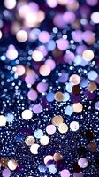 Magical purple and gold bokeh lights on dark background with glitter sparkle effect, creating dreamy abstract pattern for festive designs and celebrations.