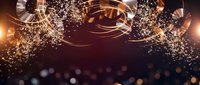 Luxury golden rings and sparkling particles create elegant abstract background with warm bokeh lights for premium design projects.