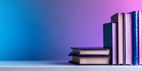 Stack of books on white surface against gradient blue and purple background, creating minimalist composition with dramatic lighting and copy space.